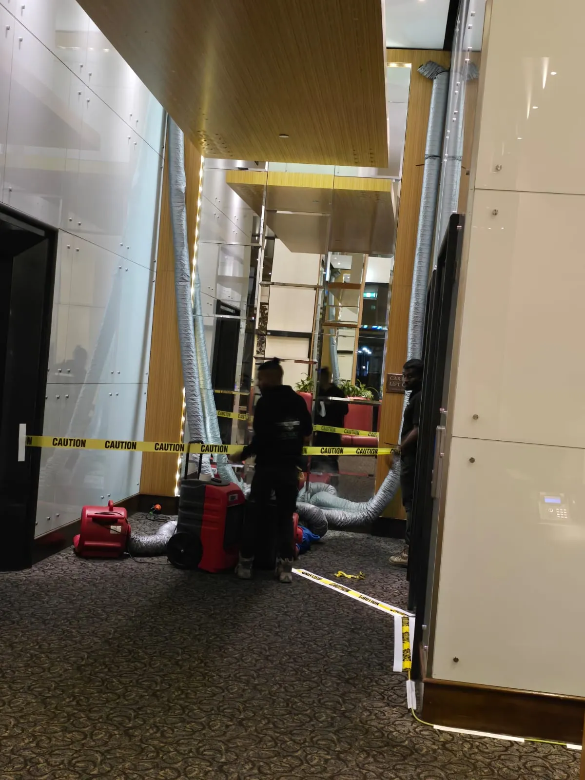 Drying under way in a public area of the hotel, with the work zone separated from guest traffic.